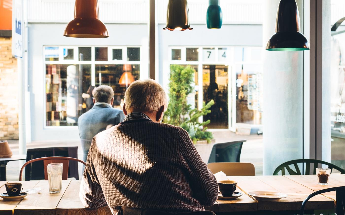 Man in coffee shop reading a newspaper